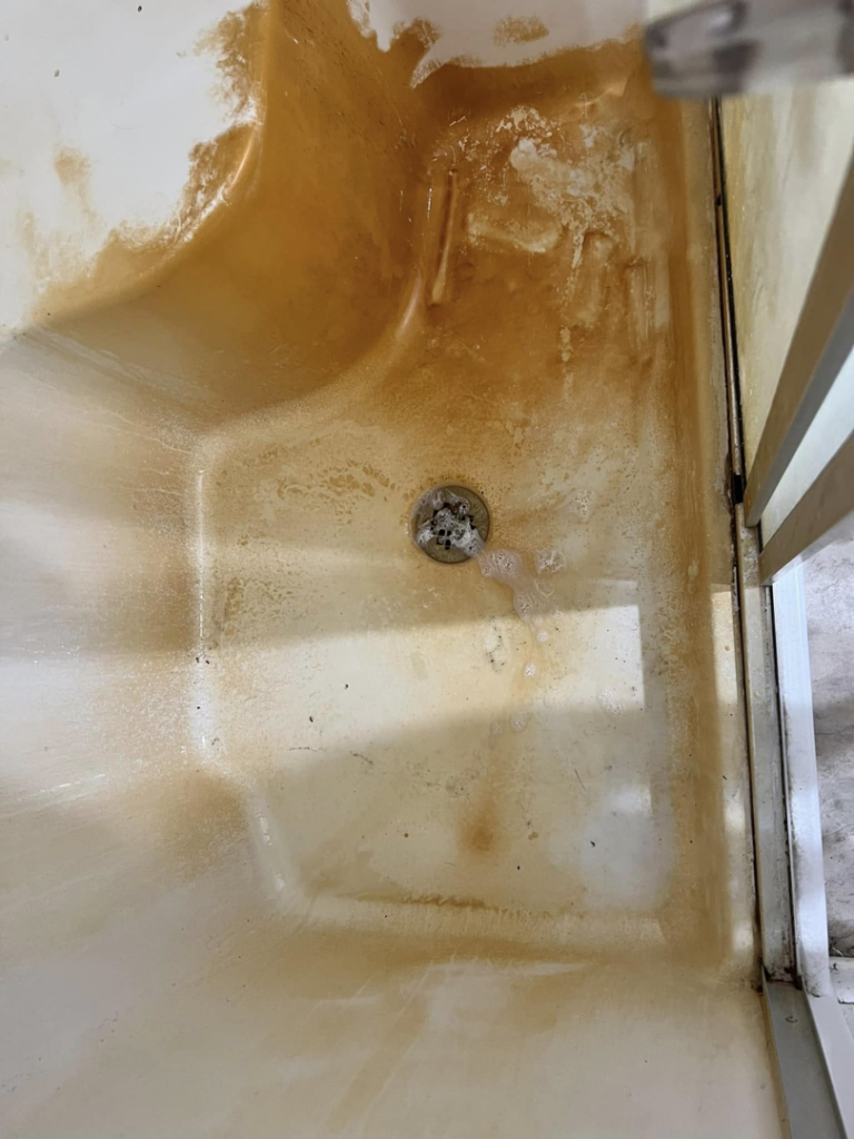 A heavily stained and dirty shower stall before professional cleaning by Stay at Home Maids in Roanoke, VA.