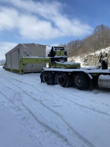 A heavy-duty crane truck lifting a large fuel tank for Harpeth Towing & Recovery in Franklin, TN.