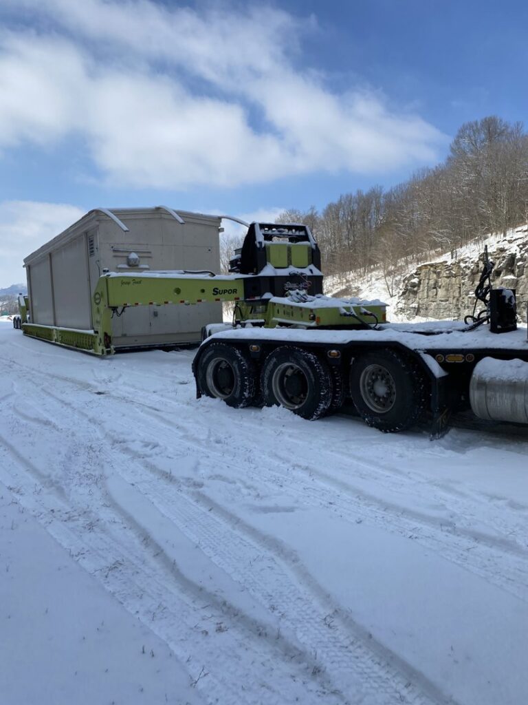 A heavy-duty crane truck lifting a large fuel tank for Harpeth Towing & Recovery in Franklin, TN.