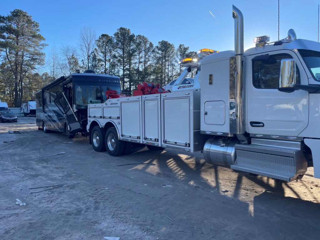 A heavy-duty tow truck from Raleigh Towing & Recovery preparing to tow a large RV in Raleigh, NC.