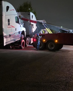 A worker connecting a semi-truck for heavy-duty towing service by Towing Near Me 247 LLC Dallas in Dallas, TX.