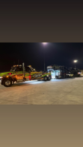 Heavy-duty tow truck hauling multiple vehicles at night for County Towing & Recovery LLC in West Columbia, SC.