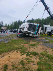 A heavy-duty tow truck from Bailey's Towing and Auto Body, LLC recovering an overturned cement mixer in Merrimack, NH.