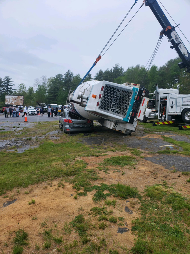 A heavy-duty tow truck from Bailey's Towing and Auto Body, LLC recovering an overturned cement mixer in Merrimack, NH.
