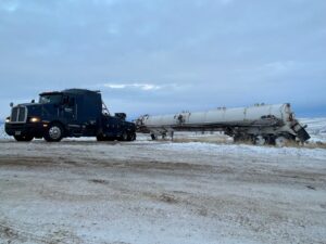 A heavy-duty tow truck from Select Towing and Recovery recovering a damaged tanker trailer from a ditch in Casper, WY.
