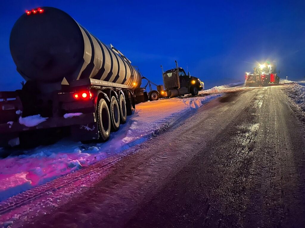 A heavy-duty tow truck from Select Towing and Recovery recovering a tanker truck from a snowy ditch in Casper, WY.