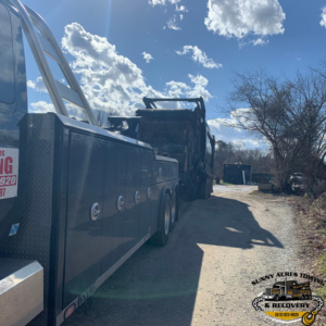 A heavy-duty tow truck from Sunny Acres Towing towing a large dump truck in Greenville, IN.