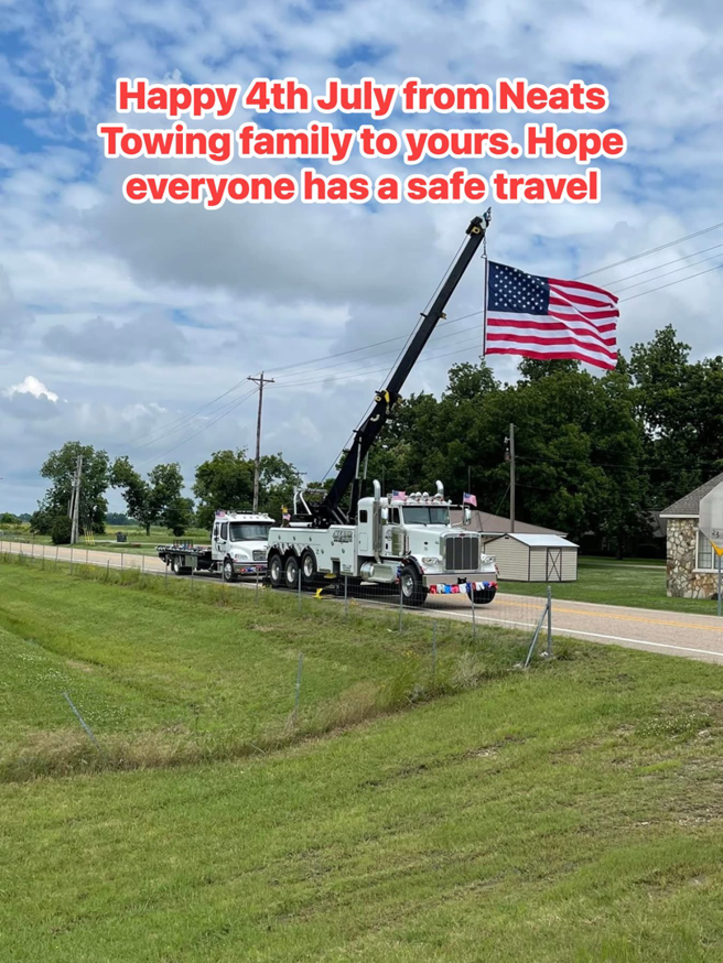A heavy-duty tow truck from NEATS Towing & Repair LLC towing another vehicle on a rural road in Jonesboro, AR.