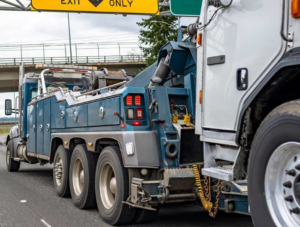 A heavy-duty tow truck actively towing another large vehicle for Rapt Roadside & Towing Services in Jacksonville, FL.