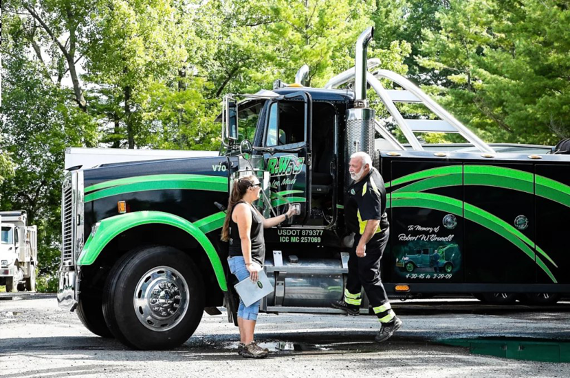 A heavy-duty tow truck with two team members from Vermont Towing Association in Brownington Village, VT.