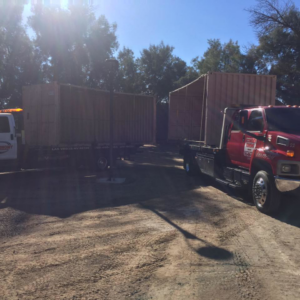 Two Economy Towing trucks providing heavy-duty transport for large shipping containers in Las Vegas, NV.