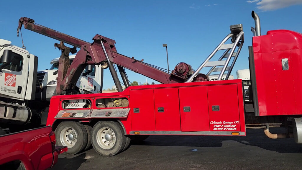 A large red heavy-duty wrecker tow truck from Towing Colorado in Colorado Springs, CO, ready for heavy vehicle recovery.