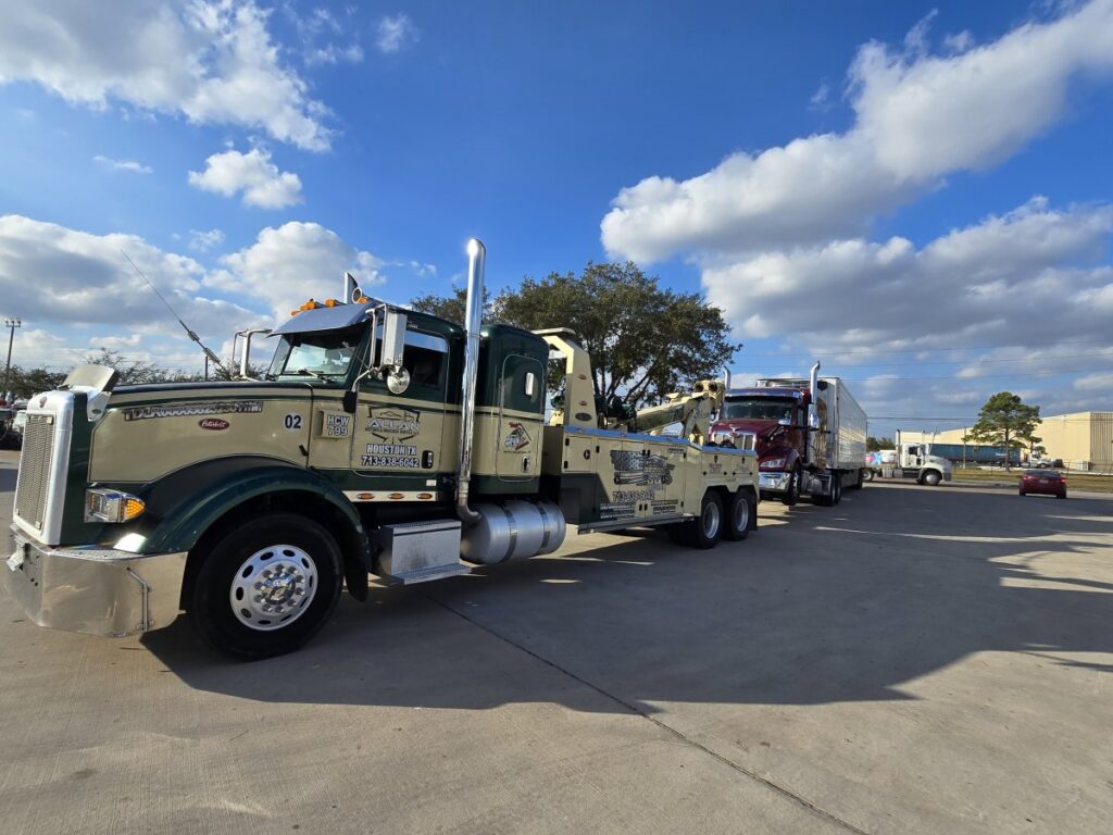 A heavy-duty wrecker from Allan Motors & Wrecker Service LLC towing a semi-truck on a sunny day in Houston, TX
