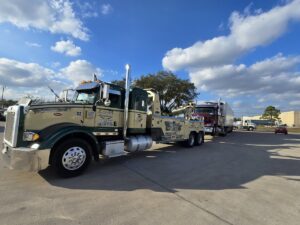 A heavy-duty wrecker from Allan Motors & Wrecker Service LLC towing a semi-truck on a sunny day in Houston, TX