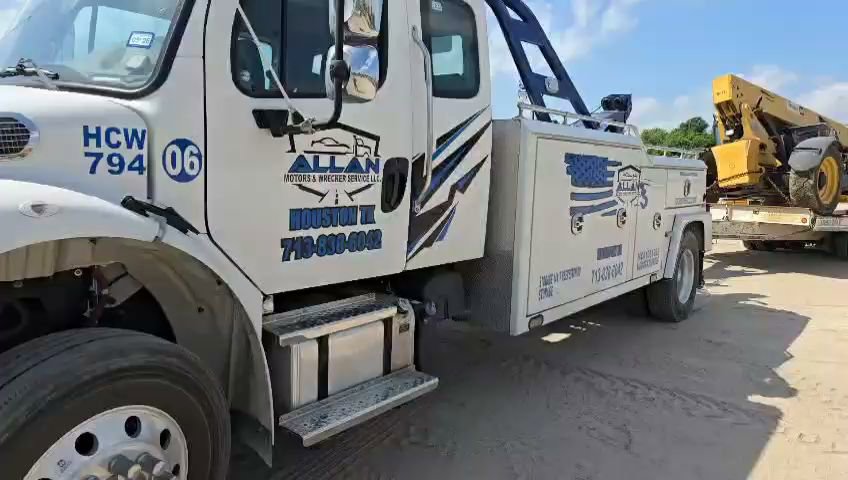 A heavy-duty wrecker from Allan Motors & Wrecker Service LLC towing a yellow telehandler in Houston, TX