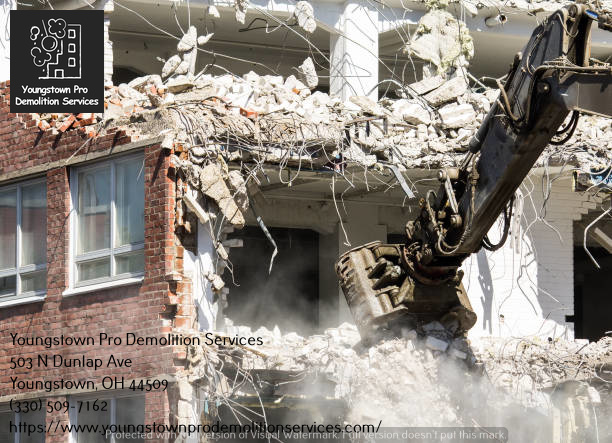 Heavy equipment with a demolition attachment breaking down a commercial building for Youngstown Pro Demolition Services in Youngstown, OH.