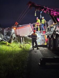 McDowell Wrecker Service performing heavy equipment recovery with a tow truck at night in Springfield, MO.