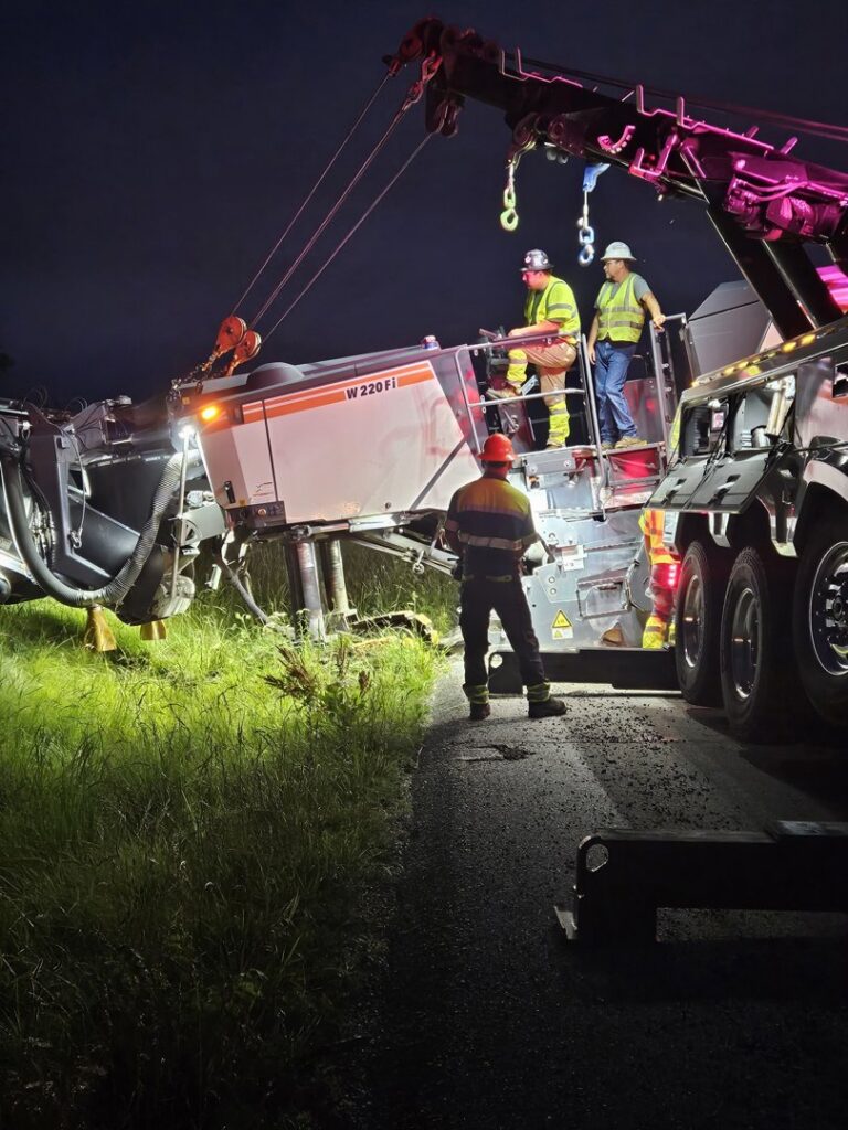 McDowell Wrecker Service performing heavy equipment recovery with a tow truck at night in Springfield, MO.