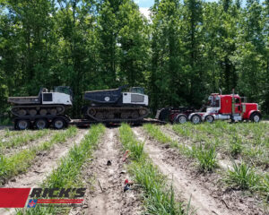 A heavy-duty truck from Rick's Towing and Recovery in Lafayette, LA, transporting two large tracked construction vehicles.
