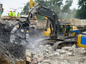 A heavy excavator with a concrete crushing attachment performing demolition for San Antonio Demolition Pros in San Antonio, TX.