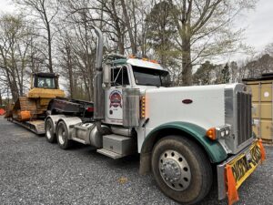 A heavy-duty tow truck hauling a bulldozer on a lowboy trailer for Southern Maryland Towing in Prince Frederick, MD.