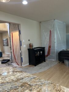 Home interior with plastic containment barriers and drying equipment for water damage restoration by Verg Restoration in Vancouver, WA
