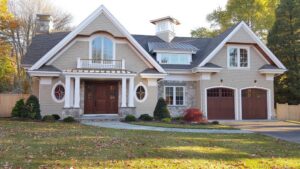 A charming house with new beige shingle siding and elegant stone accents, completed by JM Roofing & Siding in Rogers, AR.