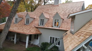 A house featuring natural cedar shake siding and roofing, indicating a recent project by JM Roofing & Siding in Rogers, AR.