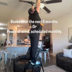 A professional house cleaner from Kleen-It Maids cleaning a ceiling fan in a home in Fort Worth, TX.