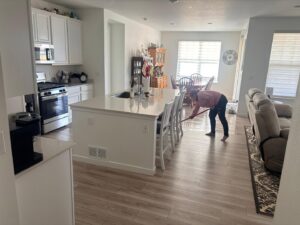 A house cleaner mopping the kitchen floor in a home by Doozy Cleaning Services in Denver, CO.