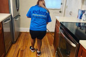 A house cleaner from Eden Cleaning Services mopping a kitchen floor in a home in Annapolis, MD.