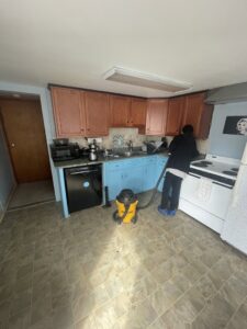 A house cleaner vacuuming a kitchen floor for North Star Cleaning in Fall River, MA.