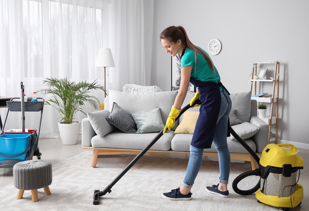 A professional house cleaner vacuuming a living room carpet for Rose Residential Cleaning in Tampa, FL