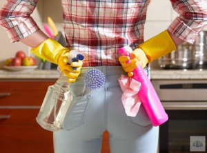 A house cleaner holding various cleaning supplies in a kitchen for All Advanced Tactical Klean LLC in Columbus, OH.