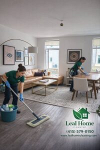 Two house cleaners mopping a floor and wiping a dining table for Leal Home Cleaning in San Francisco, CA.