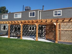 A house with dark gray horizontal siding and a wooden pergola in the backyard, a project by Urban Exteriors LLC in Lakewood, CO.
