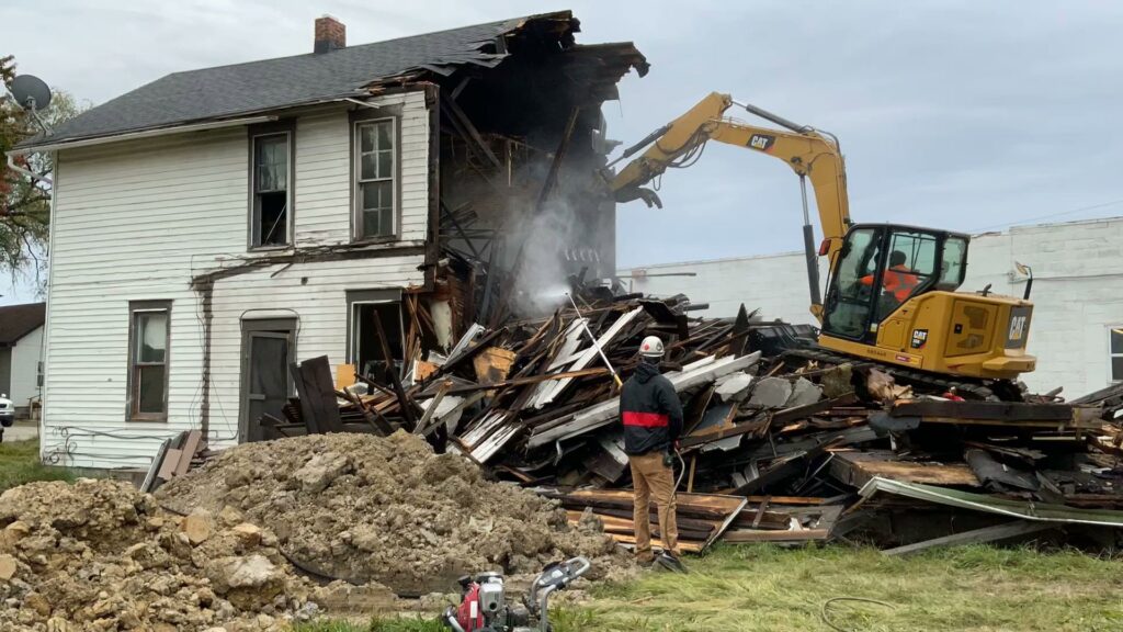 An excavator from Just Take It, LLC. actively demolishing a residential house, creating a pile of debris in Yorba Linda, CA.