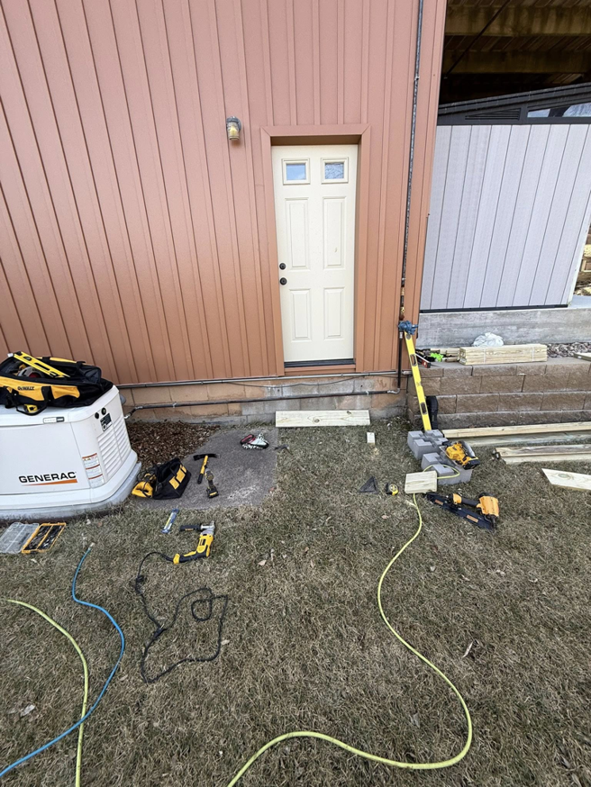 House exterior with brown vertical siding and construction tools on the ground by Peña Industries LLC in Bellevue, NE.