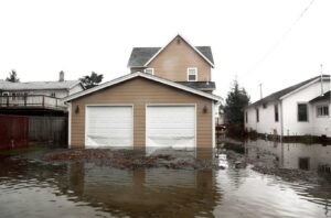 A house with a flooded driveway and garage, clearly showing severe water damage handled by Royal Restoration in Enid, OK.