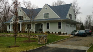 A beautiful house with light green horizontal and shake siding, expertly installed by JM Roofing & Siding in Rogers, AR.