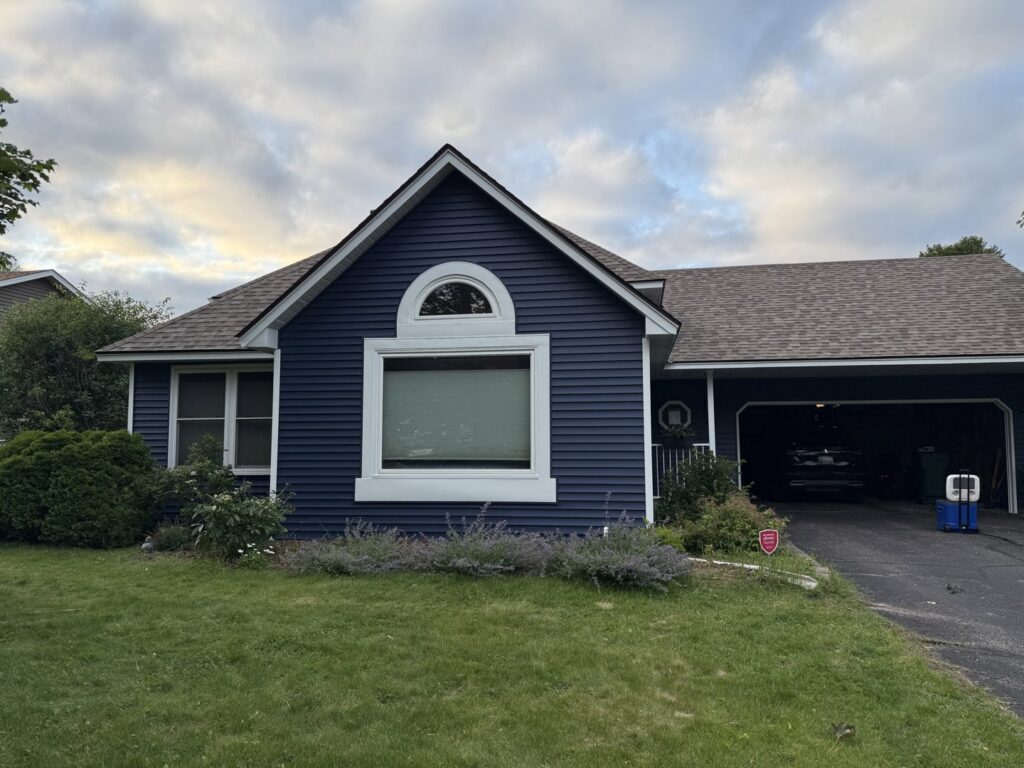 A residential house featuring newly installed dark blue siding by Storm Group Roofing in Brooklyn Park, MN.