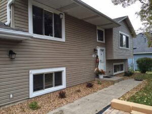A residential house with newly installed light brown siding by Storm Group Roofing in Brooklyn Park, MN.