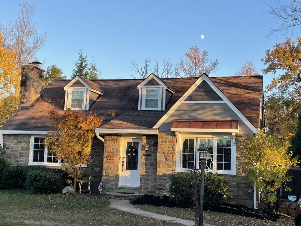 Charming house with stone facade and new gray siding installed by High Quality Exteriors in Rockville, MD.