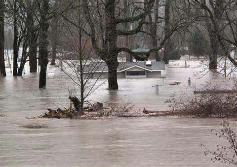 A house partially submerged in floodwaters, demonstrating the need for water damage restoration by 1st Choice Fire and Water Restoration in South Bend, IN.