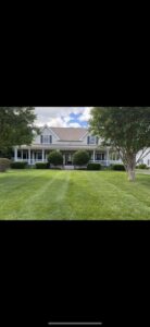 A house with a neatly mowed lawn and well-trimmed bushes, reflecting the quality work of A & J Lawn Care LLC in Seaford, DE.