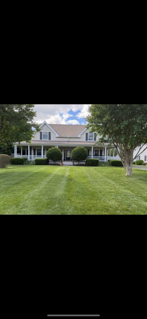 A house with a neatly mowed lawn and well-trimmed bushes, reflecting the quality work of A & J Lawn Care LLC in Seaford, DE.