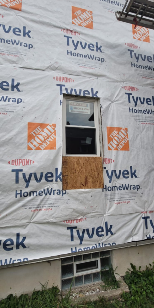 Side of a house wrapped in Tyvek HomeWrap, prepared for new siding installation by Lap Vinyl Siding Repair Columbus OH.