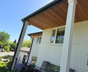 Side view of a house featuring white brick siding and a natural wood soffit, completed by Urban Exteriors LLC in Lakewood, CO.