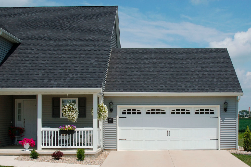 A house with a classic white garage door featuring windows and hardware by Jim Dyer Overhead Door in Carson City, NV