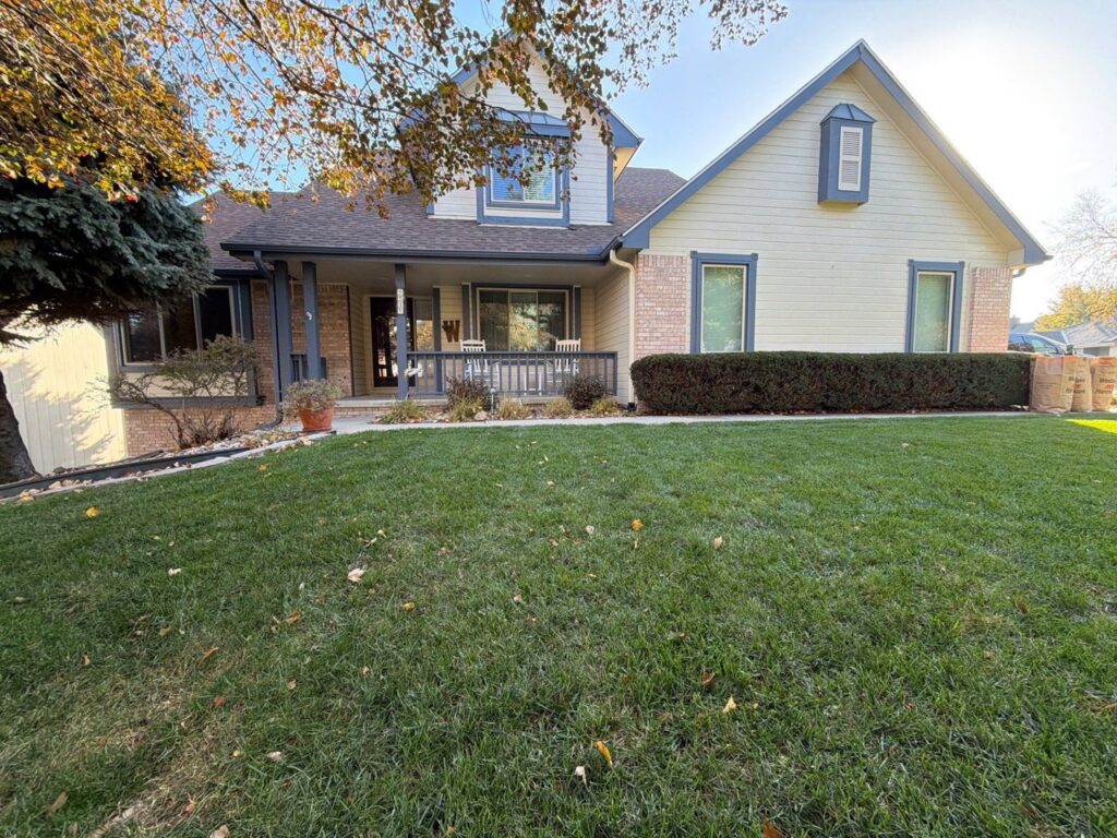 A residential home with new beige siding and a well-maintained front yard, completed by Bishop Exteriors in Omaha, NE.